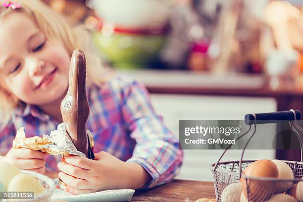 niedlich kleines mädchen eröffnung schokolade ostern hase - chocolate bunny stock-fotos und bilder