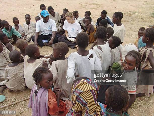 Goodwill Ambassador Angelina Jolie is shown in this UNHCR handout photo talking to children in a displaced persons camp on October 26, 2004 in...