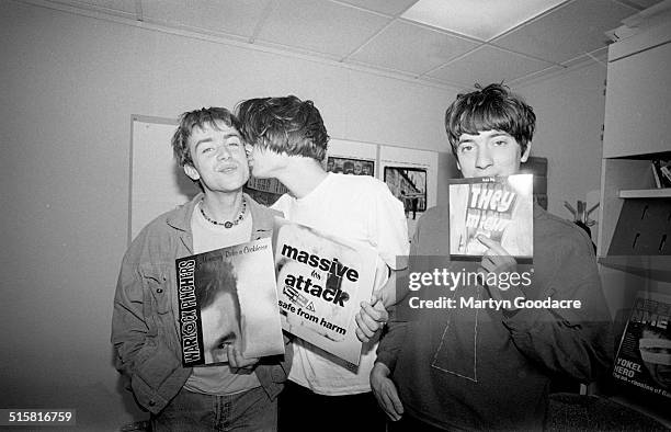 Three members of Blur pose in the NME offices while reviewing that week's single releases, London, 1991. L-R are Damon Albarn, Alex James and Graham...
