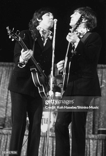 Paul McCartney and John Lennon of The Beatles share a microphone while performing at Dodger Stadium, Los Angeles, California, August 28, 1966.