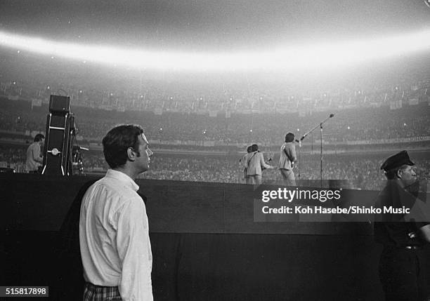 The Beatles' manager Brian Epstein watches from the side of the stage as the band perform at Shea Stadium, New York, August 23, 1966.