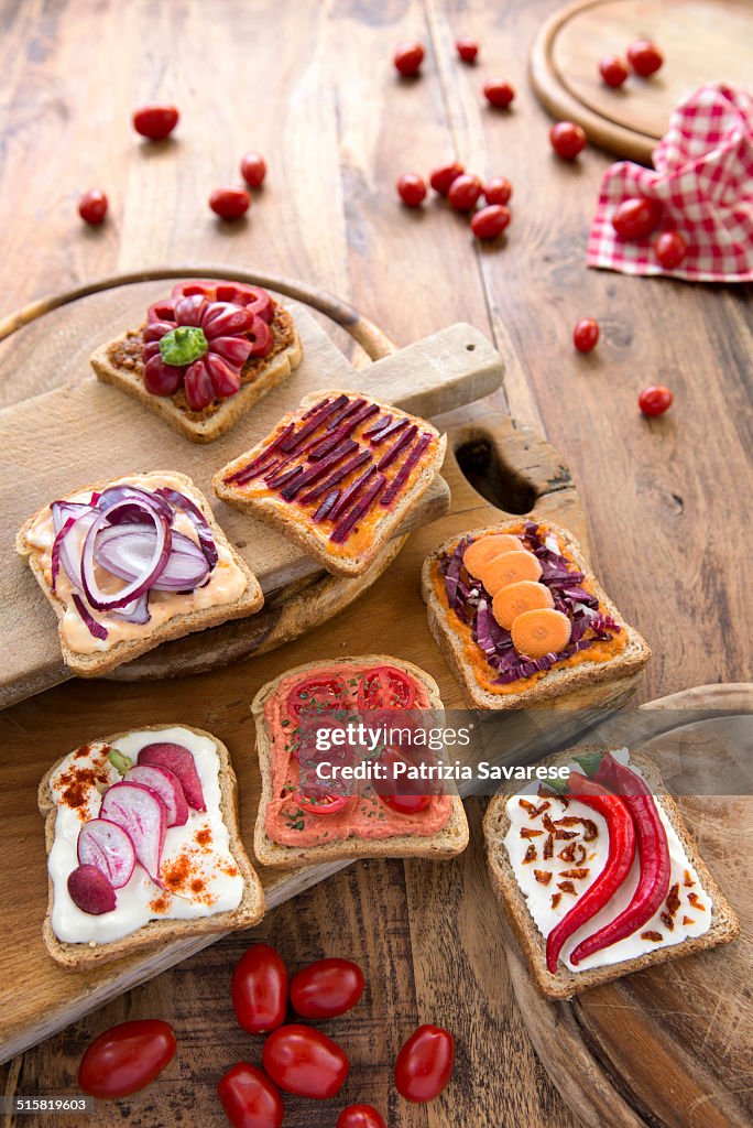 Vegetarian appetizers and bruschetta on wooden cho