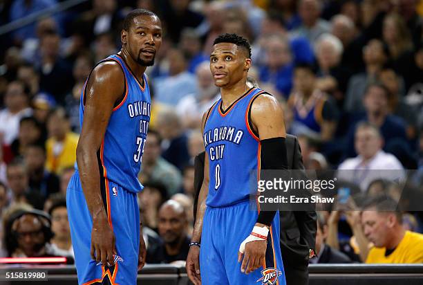 Kevin Durant and Russell Westbrook of the Oklahoma City Thunder talk to head coach Billy Donovan during their game against the Golden State Warriors...