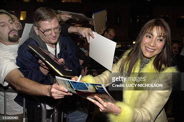 Malaysian-born actress Michelle Yeoh signs autographs as she arrives at the premiere of her new film "Crouching Tiger, Hidden Dragon" in Beverly...