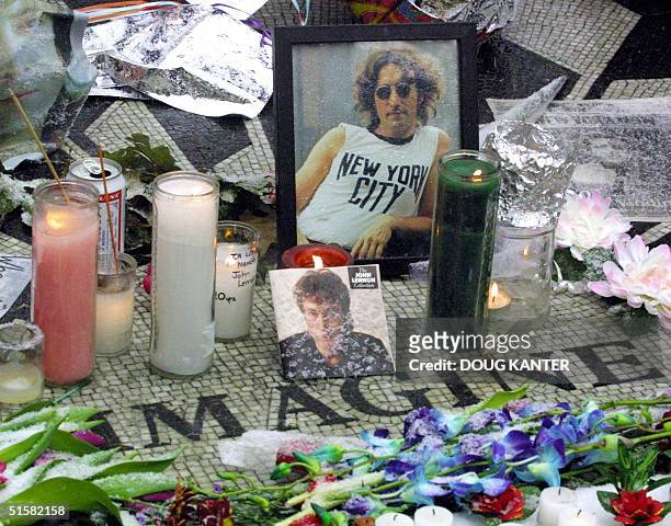 Flowers and candles adorn a memorial to slain singer John Lennon in the Strawberry Fields section of Central Park in New York, 08 December 2000....