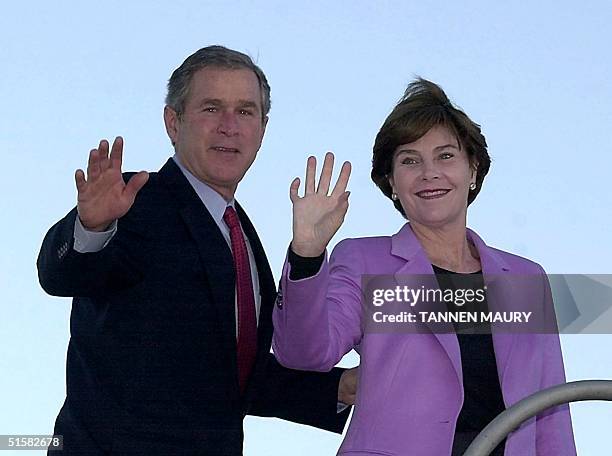 President-elect and Texas Governor George W. Bush and his wife Laura wave as they board a plane 17 December 2000 in Austin, Texas, for his first trip...