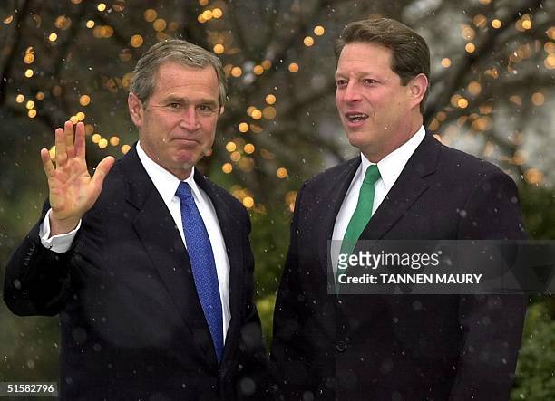 President-elect George W. Bush waves as he is greeted by Vice president Al Gore at Gore's residence in Washington, DC 19 December, 2000. Bush, who...
