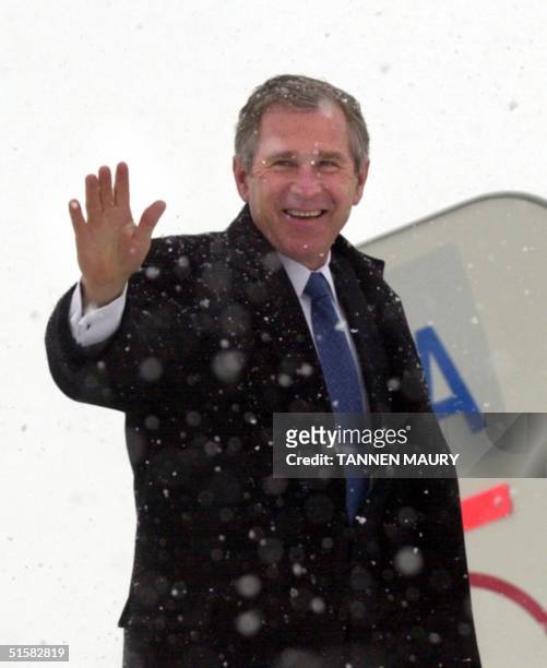 President-elect George W. Bush waves as he prepares to board his plane in Washington, DC during a snow storm for his return to Austin, Texas 19...