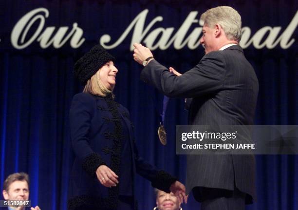 President Bill Clinton bestows the National Medal of Arts award to US singer/actress Barbra Streisand during ceremonies 20 December, 2000 at...