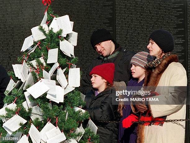 The Rosenberg family from Oakland, CA, from left, Alexa, Bill, Ariane and Kathi read Christmas cards 21 December, 2000 placed on a tree in front of...
