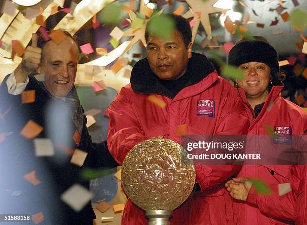 Former boxer Muhammad Ali is joined by his wife Lonnie and New York Mayor Rudy Giuliani in Times Square 31 December 2000. Ali pressed the button to...