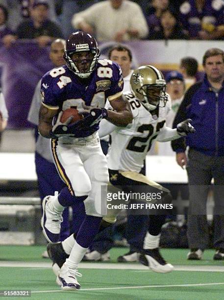 Randy Moss of the Minnesota Vikings runs past Fred Thomas of the New Orleans Saints on his way to the first touchdown of the game 06 January, 2001...