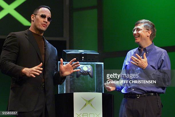 Bill Gates of Microsoft speaks with World Wrestling Federation star "The Rock" after Gates unveiled the new Xbox video game console at the Consumer...