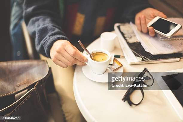Junger Mann trinken espresso und SMS in einem Café