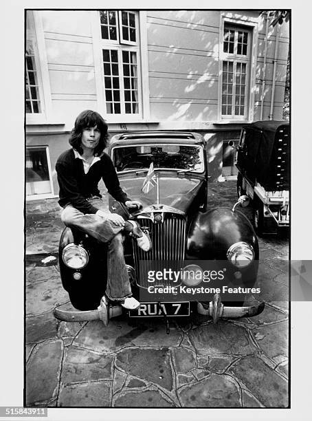 Portrait of musician Chris Jagger with sitting on the bonnet of his car, brother of pop singer Mick Jagger, circa 1968.