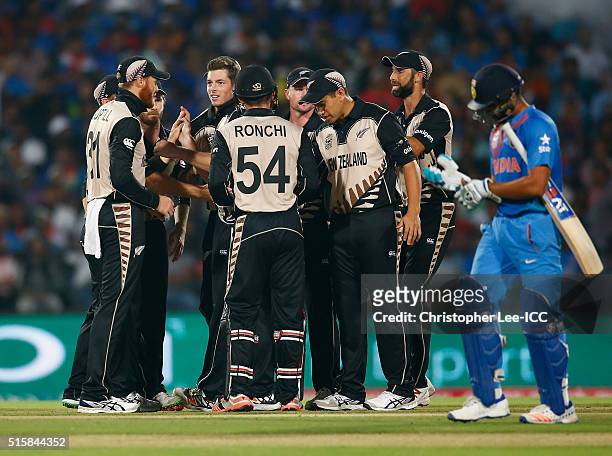 Mitchell Santner of New Zealand is congratulated by his team mates after he takes the wicket of Rohi Sharma of India during the ICC World Twenty20...