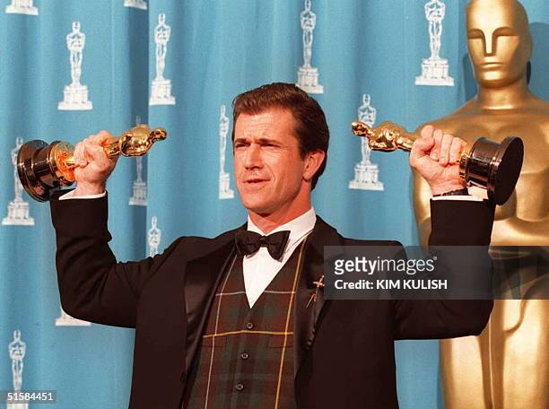 Mel Gibson, winner for Best Director and Producer for the movie "Braveheart," holds his two Oscars 25 March 1996 at the Academy Awards in Los...