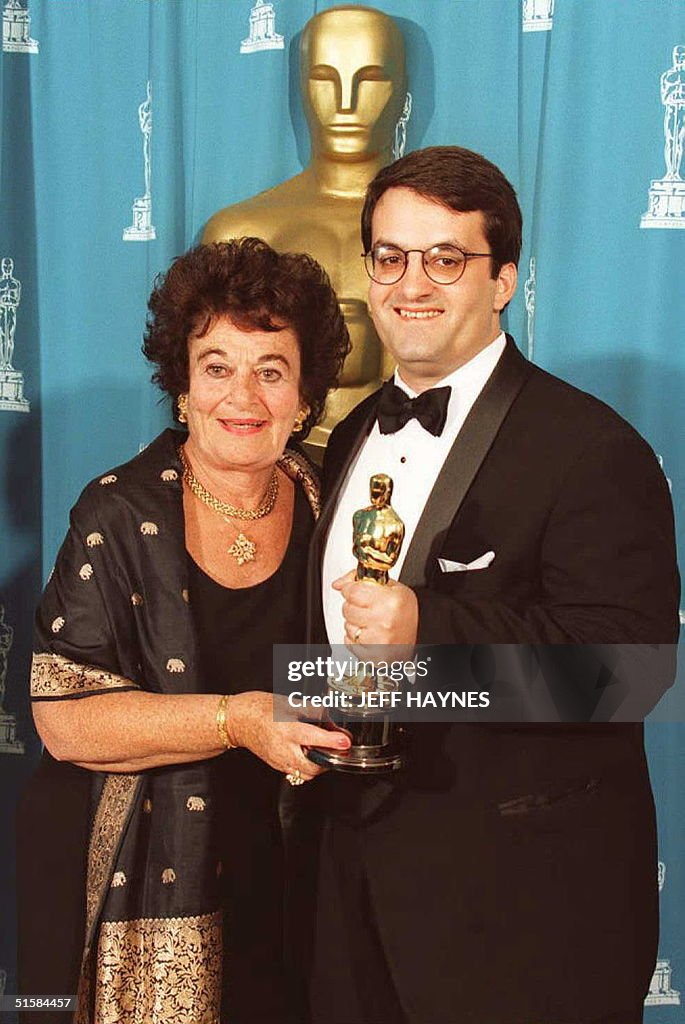 Kary Antholis (R) holds the Oscar he won for Achie