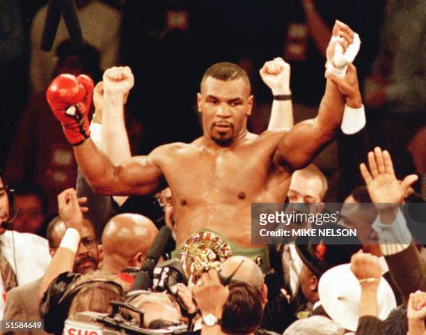 New World Boxing Council heavyweight champion Mike Tyson is lifted into the air wearing the championship belt after defeating WBC heavyweight...