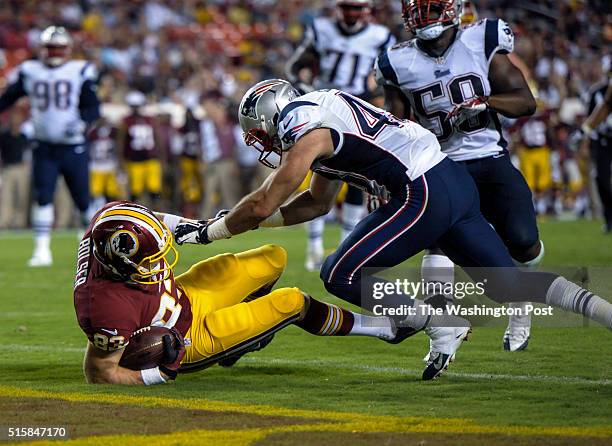 Washington Redskins tight end Ted Bolser rolls into the end zone for a touchdown as he is pushed by New England Patriots defensive back Nate Ebner in...