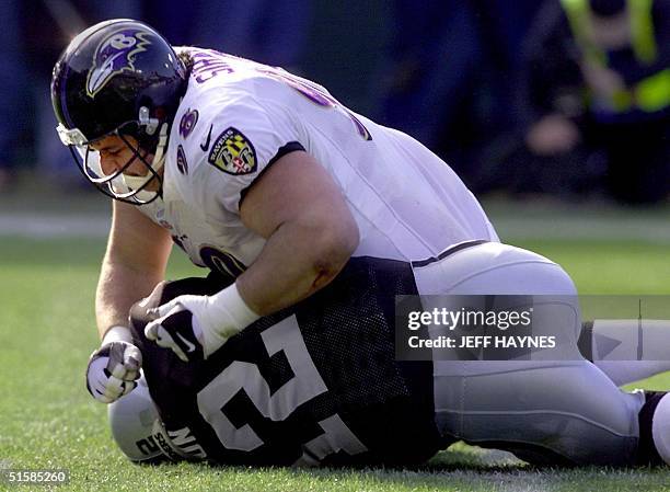 Oakland Raiders quarterback Rich Gannon lies on the ground after being tackled by the Baltimore Ravens Tony Siragusa in the second quarter of their...
