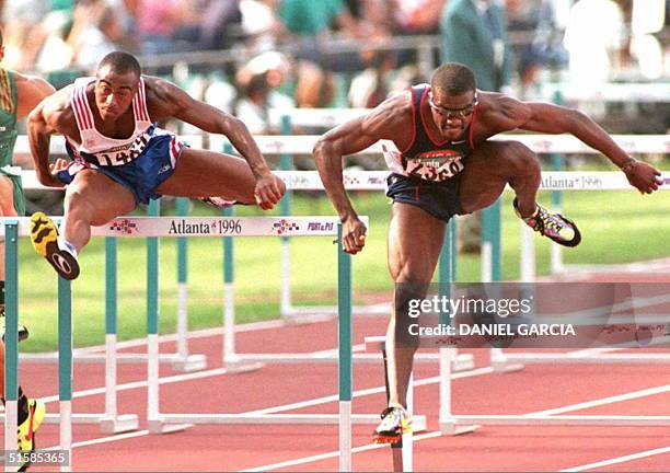 Allen Johnson of the US knocks down the last hurdle as Britain's Colin Jackson clears it 29 July during the 110m semi-finals heat one at the Olympic...