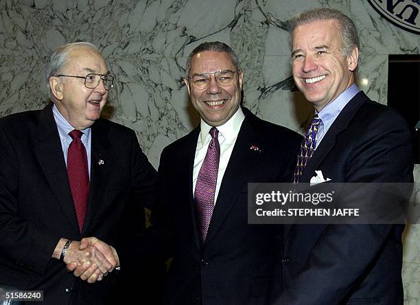 Secretary of State-designate retired General Colin Powell shakes hands with Committee Chairman Senator Jesse Helms R-NC, and Senator Joe Biden, D-DE...