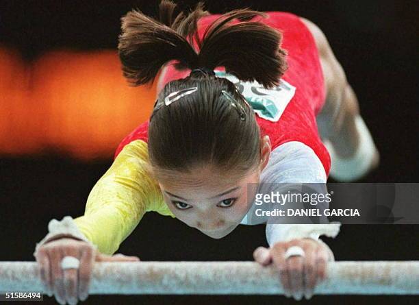 China's Bi Wenjing performs on the uneven bars 23 July during the Olympic women's team gymnastic competition in Atlanta. The US won the gold medal...