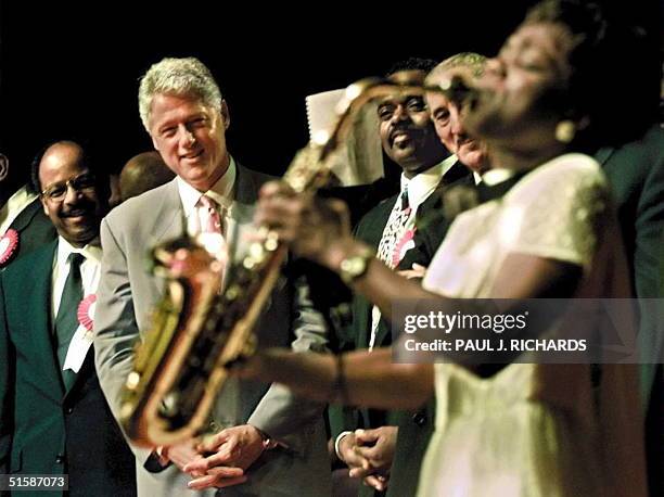 President Bill Clinton , Reverend Henry Lyons, and Reverend Roscoe Cooper watch church member Angella Christi play a solo on her saxaphone 06...