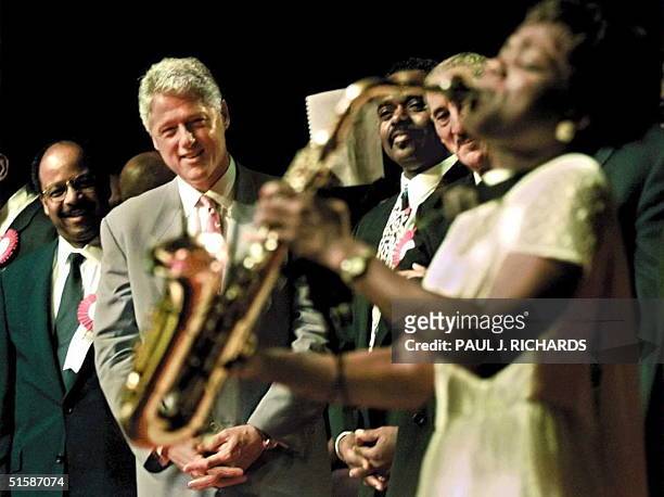 President Bill Clinton , Reverend Henry Lyons, and Reverend Roscoe Cooper watch church member Angella Christi play a solo on her saxaphone 06...