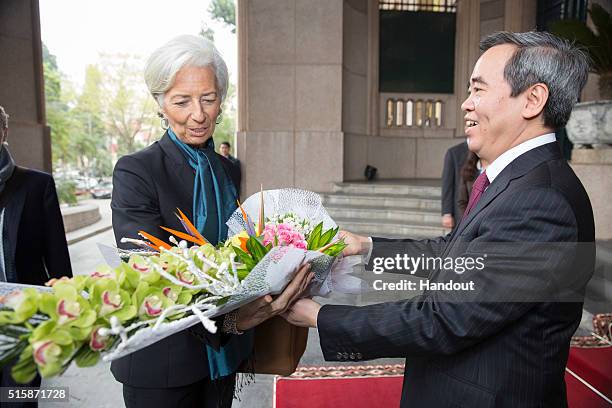 In this handout photo provided by the International Monetary Fund , International Monetary Fund Managing Director Christine Lagarde receives flowers...