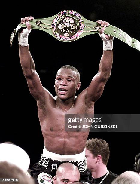 Super Featherweight Champion Floyd Mayweather, of Grand Rapids, MI, holds up his belt after beating Diego Corrales, of Sacramento, CA, late 20...