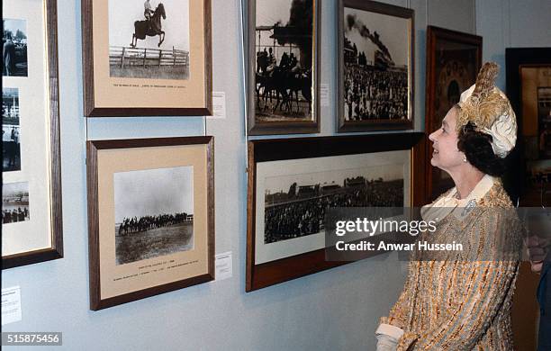 Queen Elizabeth ll looks at a gallery of pictures when she attends the Melbourne Cup horse race during a tour of Australia on November 03, 1981 in...