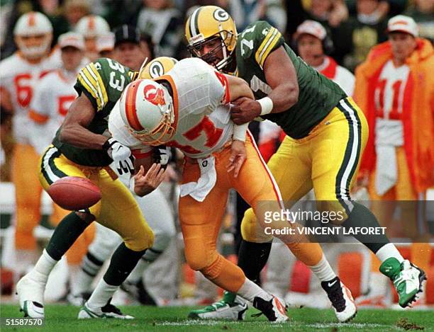 Green Bay Packers cornerback Doug Evans and defensive tackle Santana Dotson cause Tampa Bay Buccaneers safety John Lynch to fumble the ball for a...
