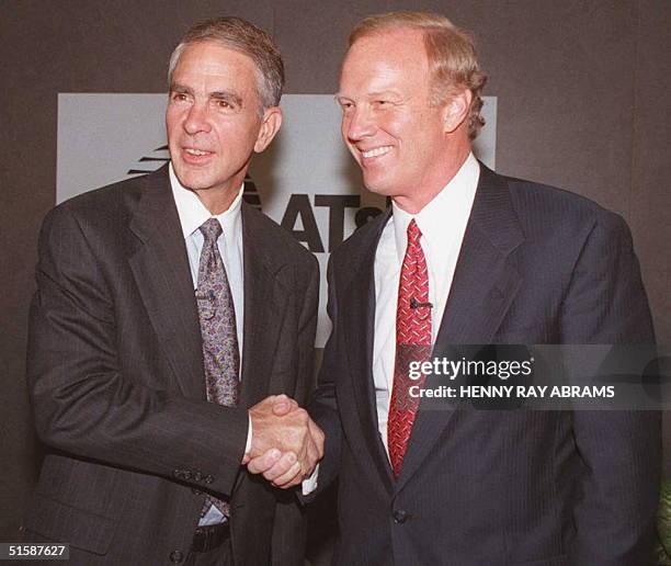 Chairman Robert Allen shakes hands with John Walter after a press conference at which Walter was introduced as the new president, chief operating...