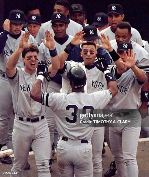 New York Yankee Darryl Strawberry is congratulated by his team as he walks back to the dugout after his home run in the third inning of game five of...