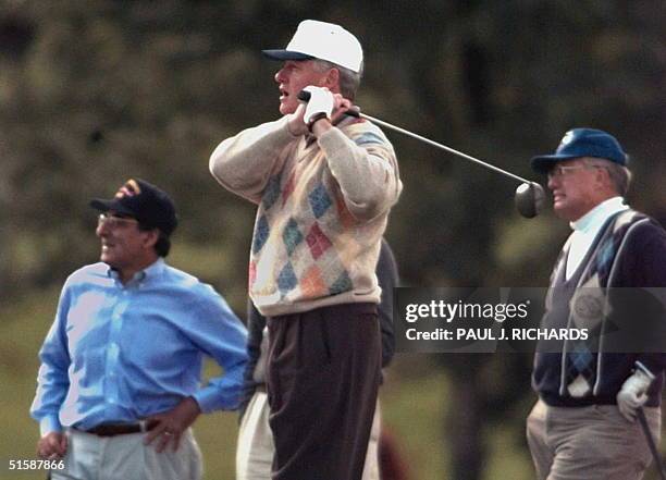 White House Chief of Staff Leon Panetta and golf pro Stan Marshauls watch as US President Bill Clinton drives 04 October off the first tee of the...