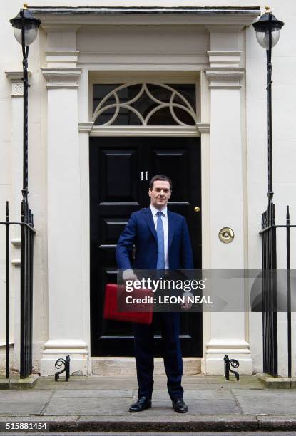 British Finance Minister George Osborne poses for pictures with the Budget Box as he leaves 11 Downing Street in London, on March 16 before...