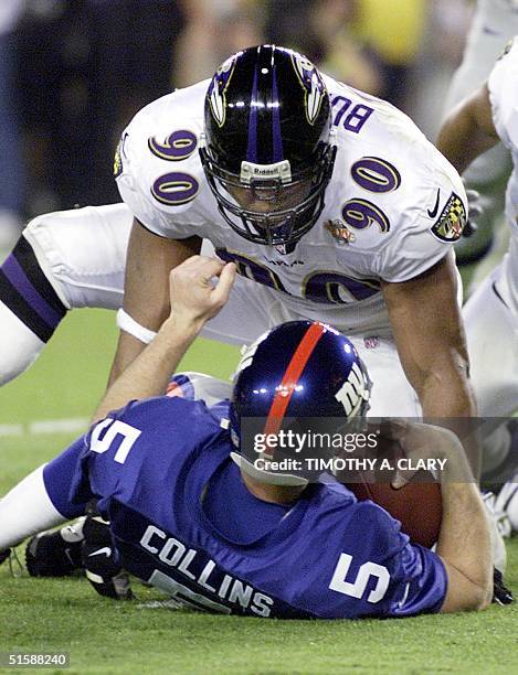 New York Giants' quarterback Kerry Collins is tackled by Baltimore Ravens' defensive end Rob Burnett during first half action of Super Bowl XXXV 28...