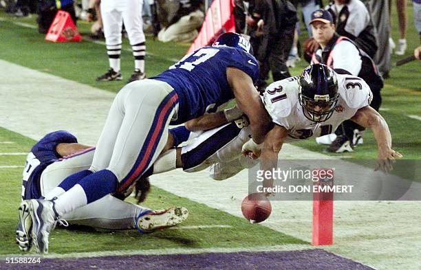 Baltimore Ravens' running back Jamal Lewis stretches the ball over the goal line for a touchdown as two New York Giant defenders attempt to stop him...