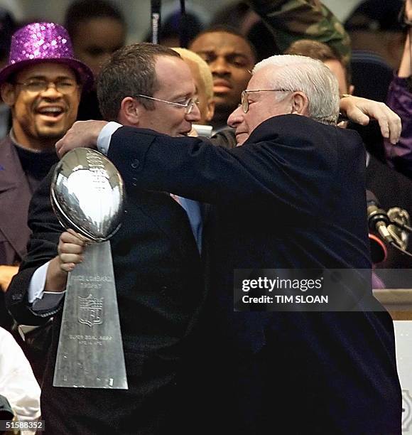 Baltimore Ravens owner Art Modell embraces his son and team President David on stage with the Vince Lombardi Trophy during a victory parade and...