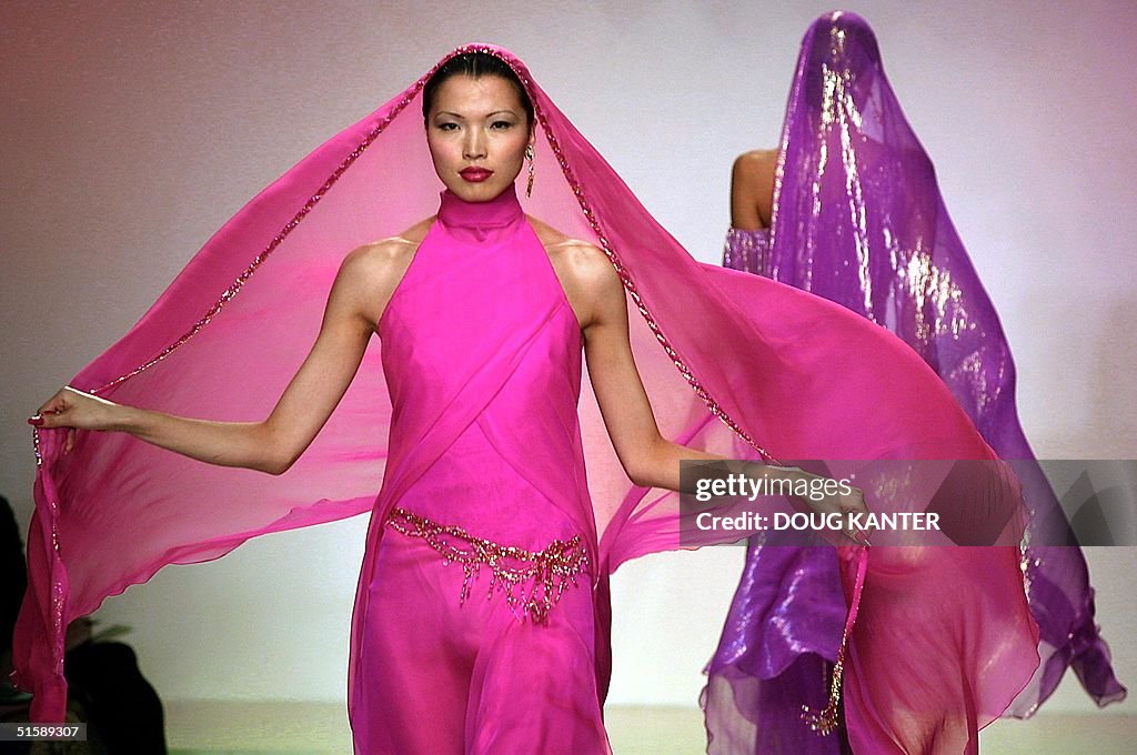 A model presents a hot pink chiffon gown with jewe