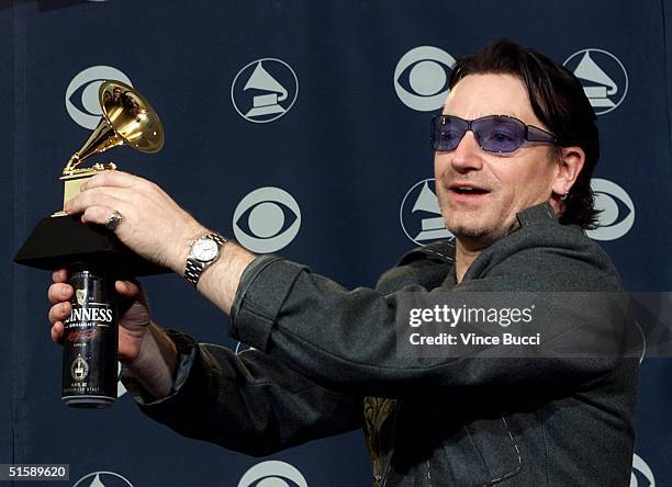 Frontman Bono poses with a Grammy Award and a Guinness Stout backstage at the 43rd Annual Grammy Awards in Los Angeles 21 February 2001. U2 won three...