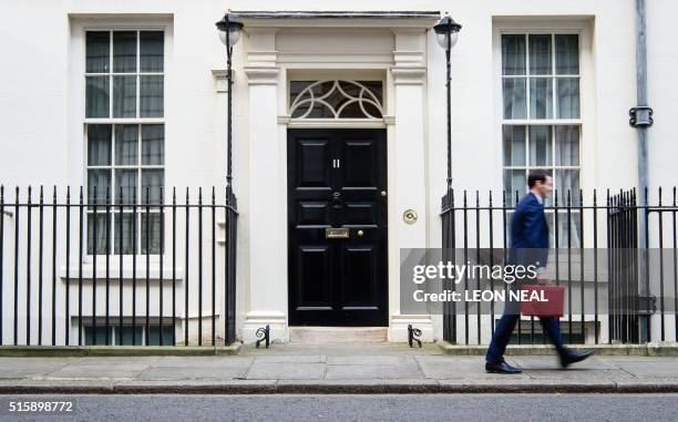 British Finance Minister George Osborne carries the Budget Box as leaves 11 Downing Street in London, on March 16 before presenting the government's...