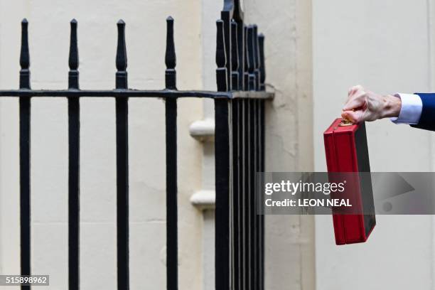 British Finance Minister George Osborne poses for pictures with the Budget Box as he leaves 11 Downing Street in London, on March 16 before...
