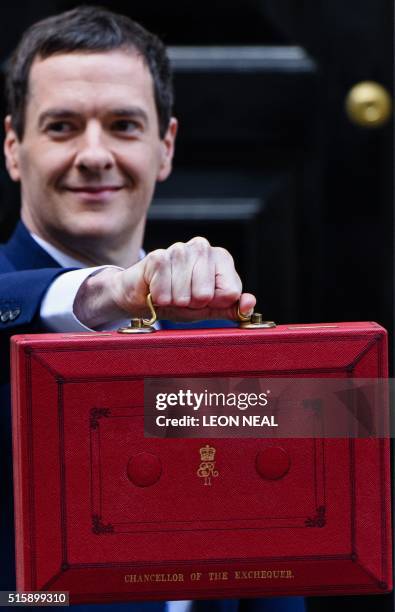 British Finance Minister George Osborne poses for pictures with the Budget Box as he leaves 11 Downing Street in London, on March 16 before...