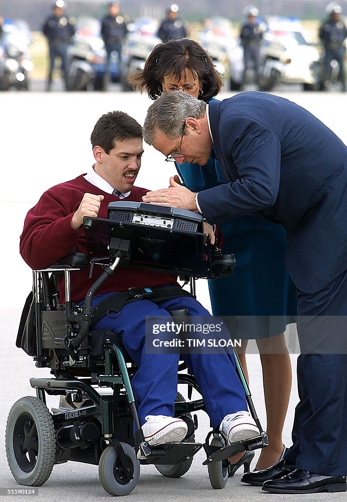 US President George W. Bush (R) looks at a compute