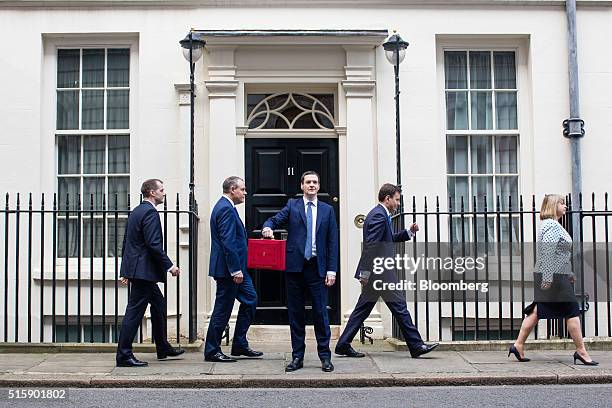 George Osborne, U.K. Chancellor of the exchequer, centre, holds the dispatch box containing the budget, as members of the H.M. Treasury team walk in...