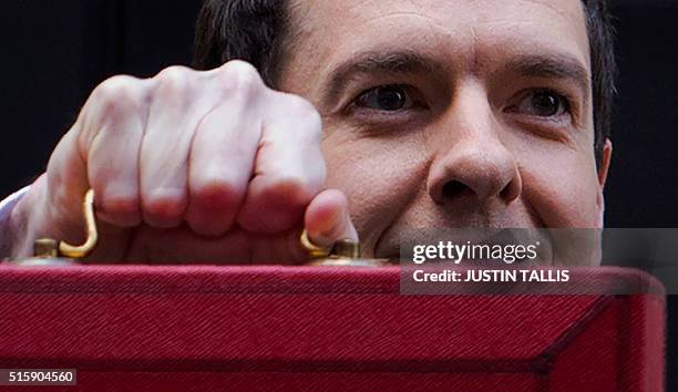 British Finance Minister George Osborne poses for pictures with the Budget Box as he leaves 11 Downing Street in London, on March 16 before...