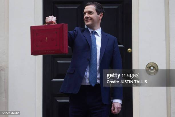 British Finance Minister George Osborne poses for pictures with the Budget Box as he leaves 11 Downing Street in London, on March 16 before...